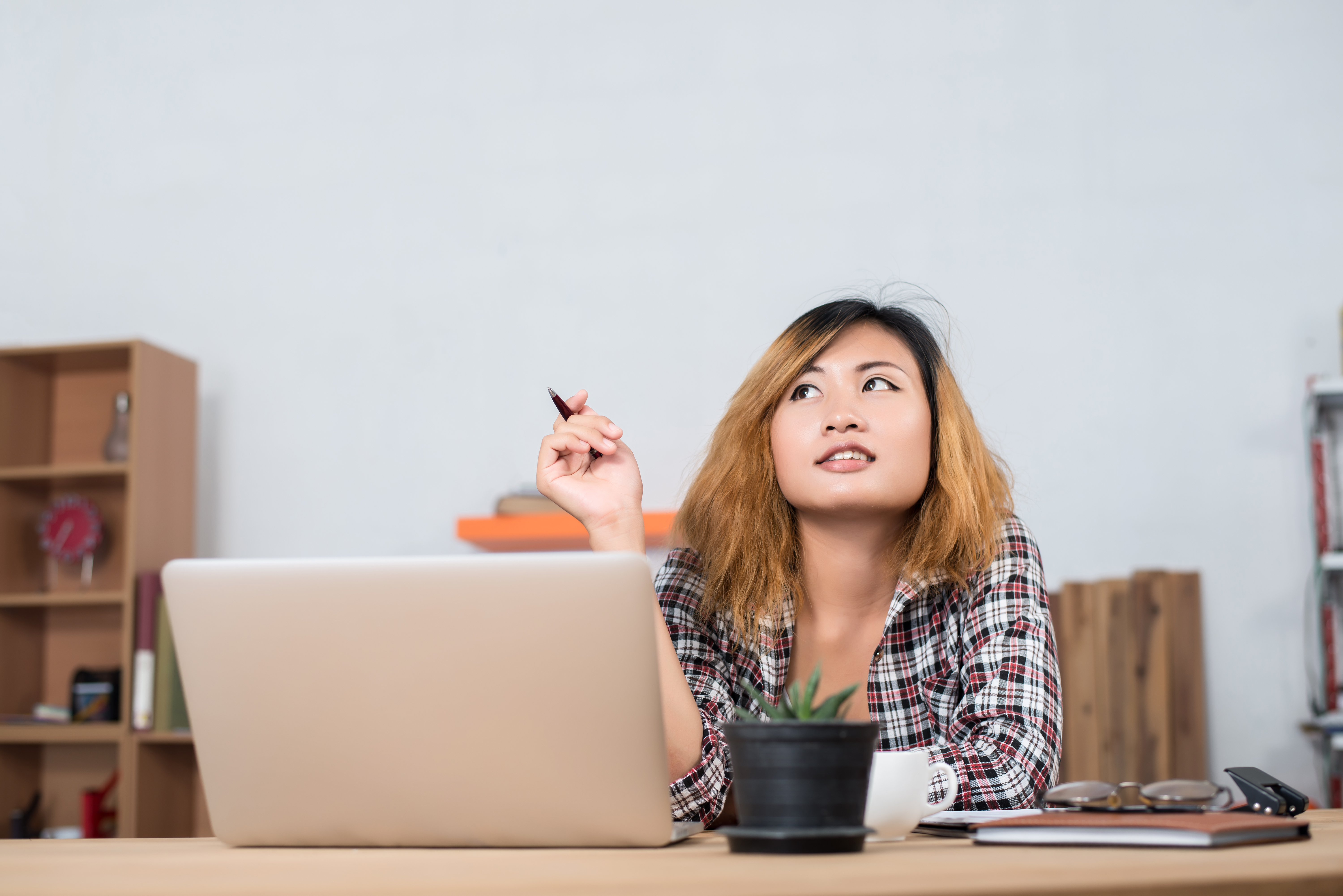 young beautiful hipster woman sitting on workplace and thinking about her work.
